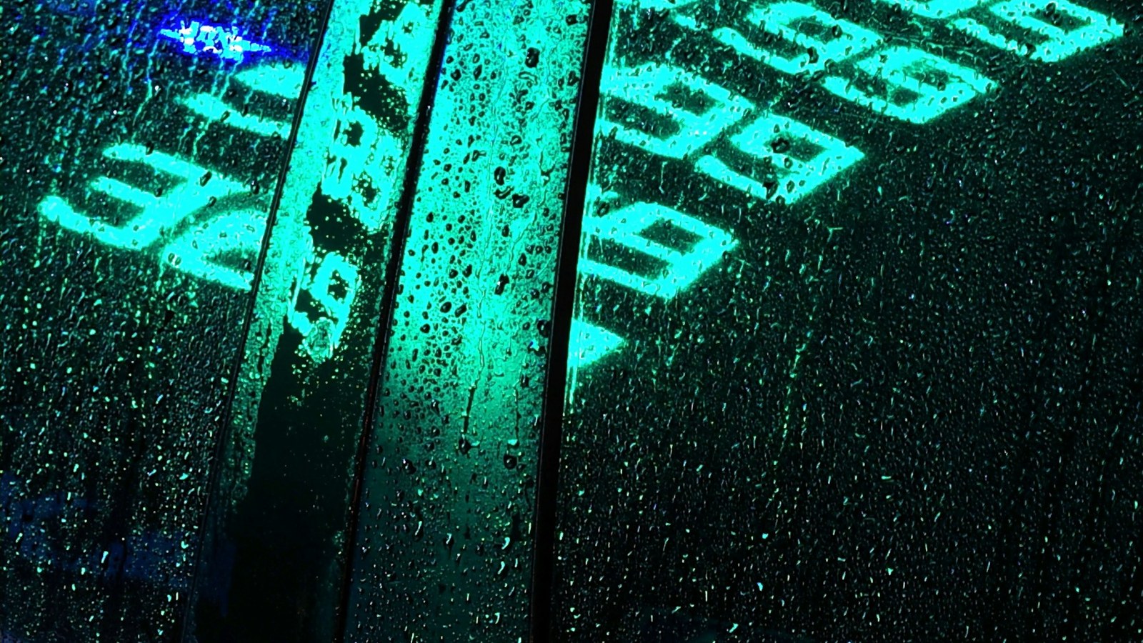 Neon numbers reflected on a wet window for an article about angel numbers and symbolic clothing