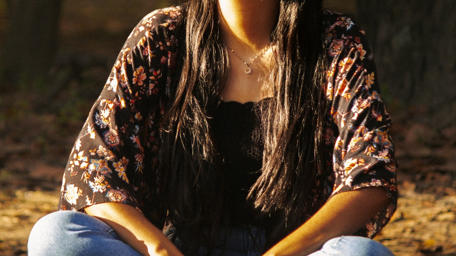 Woman meditating outdoors in a forest setting for a spiritual awakening and values-led clothing article